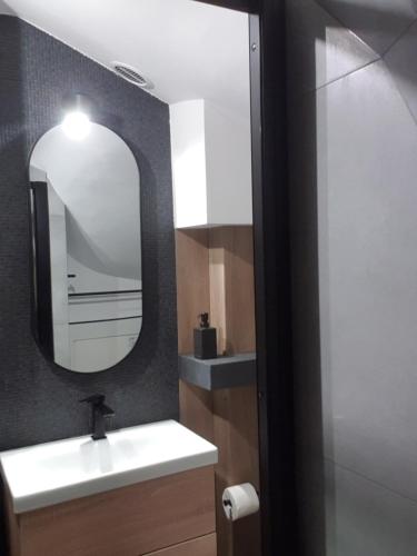 a bathroom with a sink and a mirror at Near the airport- Apartments in Kraków