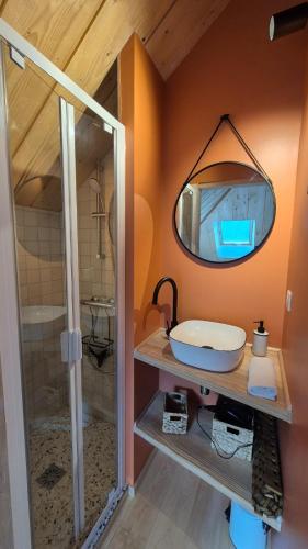 une salle de bain avec un lavabo et un miroir dans l'établissement La Charretterie-Domaine de la Valaine, à Étretat