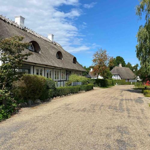a large house with a gravel road in front of it at Smukke omgivelser i Troense in Svendborg