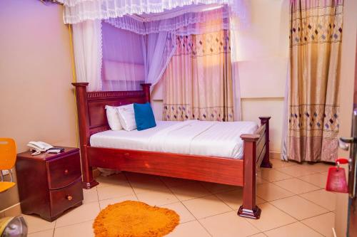 1 dormitorio con 1 cama con dosel en Twin towers hotel en Kampala