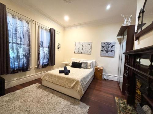 a bedroom with a bed and two windows at Subiaco 1bd In Heritage Home Gem in Perth