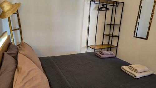 a room with a bed with two towels on it at Polichrono Cosy Summer House in Polykhrono