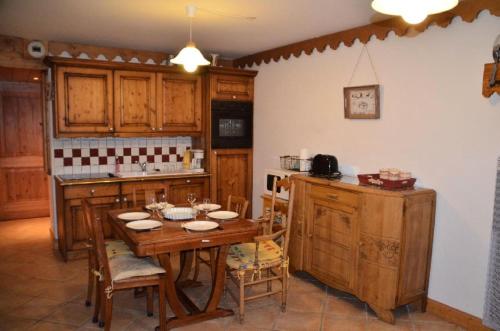 une cuisine avec une table en bois avec des chaises et un comptoir dans l'établissement Résidence Hameau Des Marmottes - 3 Pièces pour 6 Personnes 744, aux Menuires