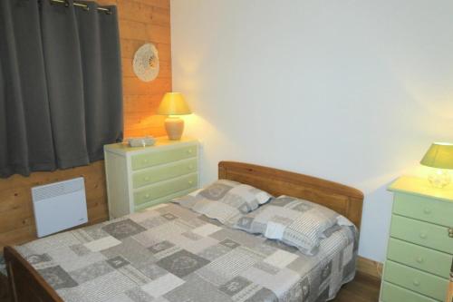 - une chambre avec un lit, une commode et une lampe dans l'établissement Résidence Hameau Des Marmottes - 3 Pièces pour 6 Personnes 744, aux Menuires