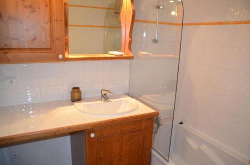 une salle de bain avec un lavabo, une douche et une baignoire dans l'établissement Résidence Hameau Des Marmottes - 3 Pièces pour 6 Personnes 744, aux Menuires