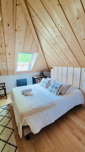 une chambre avec un grand lit dans un grenier dans l'établissement La Charretterie-Domaine de la Valaine, à Étretat