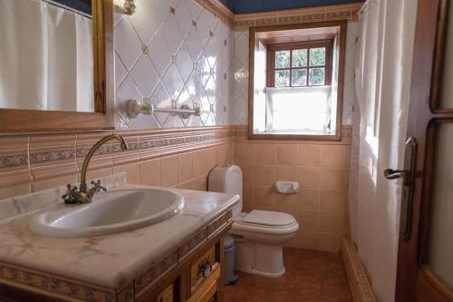 Un baño con lavabo, inodoro y ventana. en Casa Hilda 1, en El Paso