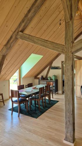 une salle à manger avec des plafonds en bois et une table et des chaises dans l'établissement La Charretterie-Domaine de la Valaine, à Étretat