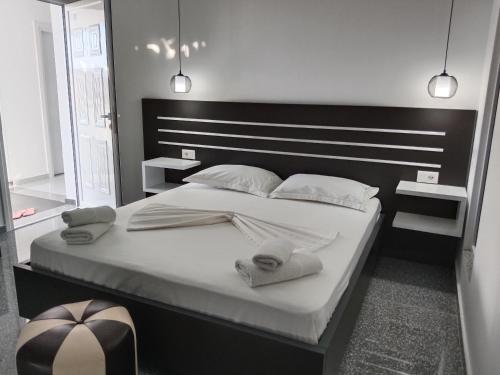 Hotel Villa Ruci في كساميل: غرفة نوم بسرير كبير عليها شراشف ووسائد بيضاء