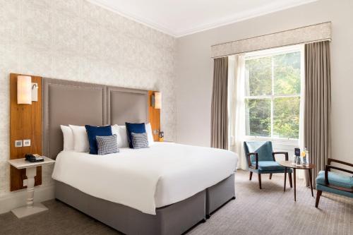 a hotel room with a large bed and a window at voco Edinburgh - Royal Terrace by IHG in Edinburgh