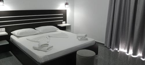 a bedroom with a bed with white sheets and pillows at Hotel Villa Ruci in Ksamil