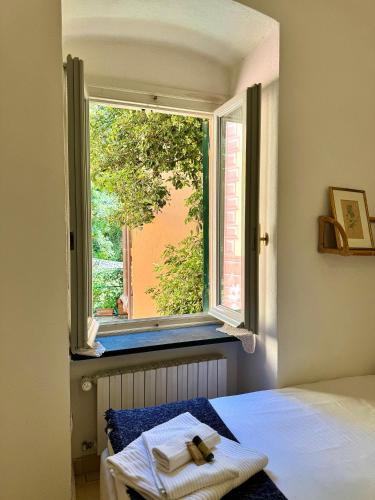 a window with a cross on a bed in a room at Casa • Paraggi • in Paraggi