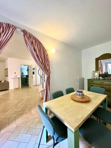 a dining room with a wooden table and chairs at Casa • Paraggi • in Paraggi