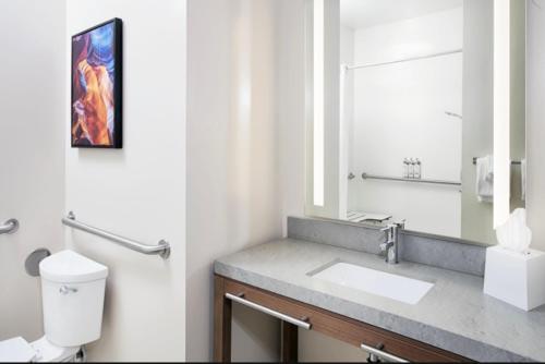 La salle de bains est pourvue d'un lavabo et d'un miroir. dans l'établissement Candlewood Suites Detroit Sterling Heights, an IHG Hotel, à Waldenburg