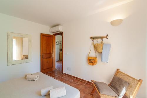 a room with a bed and a chair and a mirror at Cal Xoc - Apartamento paradisíaco junto al mar in Son Xoriguer