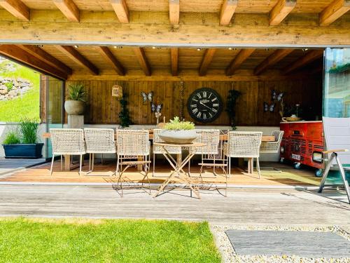 a patio with a table and chairs and a clock at Aparthotel Krösbacher in Fulpmes