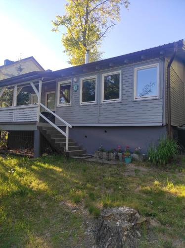 a mobile home with a porch and stairs in a yard at Domki nad jeziorem in Przechlewo