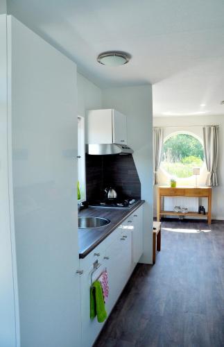 a kitchen with a sink and a counter top at BestMarine Waterchalets Flevo Marina in Lelystad