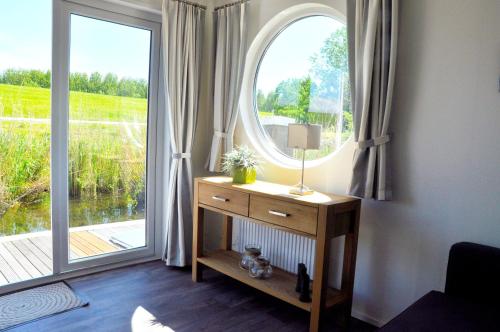 a room with a large window and a table with a lamp at BestMarine Waterchalets Flevo Marina in Lelystad