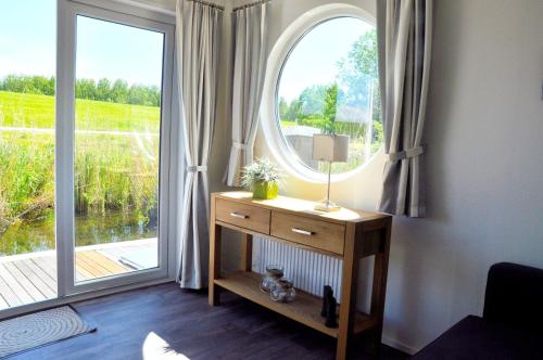 een kamer met een groot raam en een tafel met een lamp bij BestMarine Waterchalets Flevo Marina in Lelystad