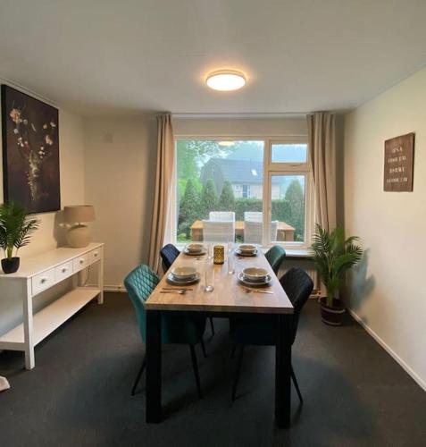 a living room with a table and chairs and a window at Morning Glory, Huisje vogelzang in Beekbergen