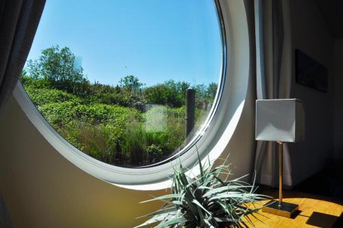 a round window in a room with a potted plant at BestMarine Waterchalets Flevo Marina in Lelystad