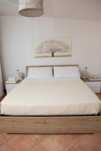 a bedroom with a large bed with white sheets at Su Hantaru Vetzu in Mamoiada