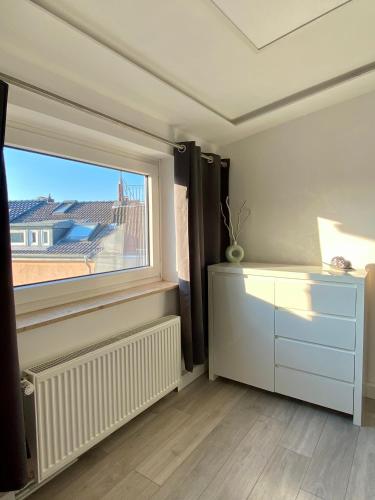 Zimmer mit einem Fenster und einer weißen Kommode in der Unterkunft Walle Retreat Zentral&Gemütlich in Bremen