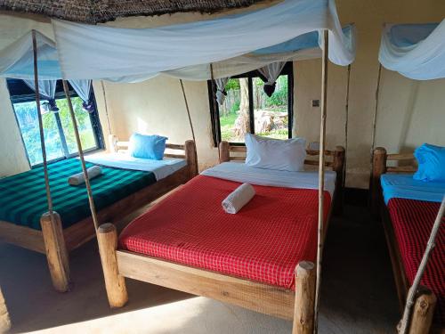 1 dormitorio con 2 camas y dosel en Sipi Guest House, en Kapchorwa