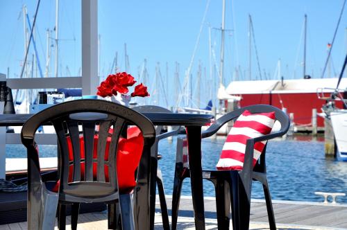 a table with two chairs and a vase with flowers on it at BestMarine Waterchalets Flevo Marina in Lelystad