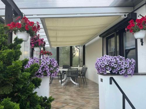 a patio with purple flowers and a table with chairs at Ferienwohnung E in Soltau