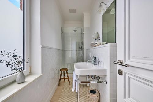 a white bathroom with a sink and a shower at Hollenstedter Hof in Hollenstedt