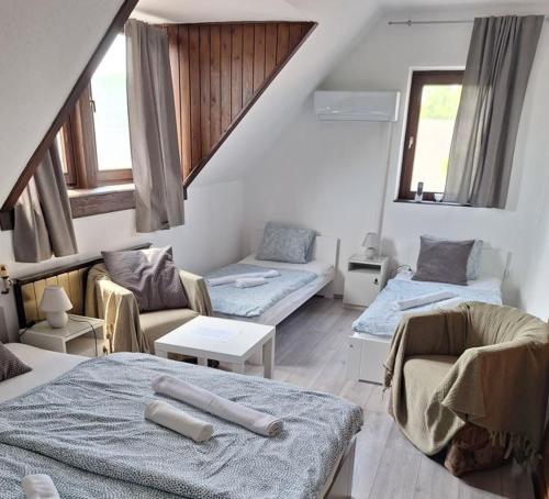a living room with three beds and a couch at Aniiza apartman in Örvényes