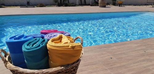 a basket of towels sitting next to a swimming pool at Alojamiento vacacional Calblanque junto Cabo de Palos in Playa Honda