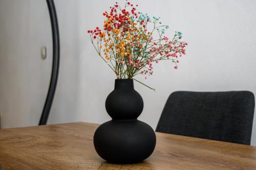 a black vase sitting on a table with flowers at AngelEve Villa with private Jacuzzi in Fira