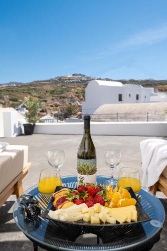 a plate of food with a bottle of wine and glasses at AngelEve Villa with private Jacuzzi in Fira