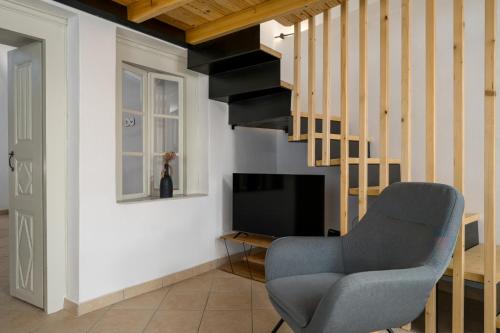 a living room with a chair and a television at AngelEve Villa with private Jacuzzi in Fira