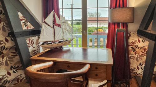 un bateau jouet posé sur un bureau à côté d'une fenêtre dans l'établissement Au verger de la Pommeraye, à Morgny-la-Pommeraye