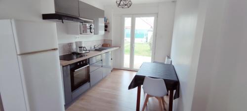 a small kitchen with a table and a refrigerator at Maison individuelle plein pied in Bray-Dunes