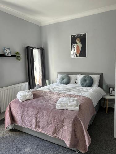 a bedroom with a large bed with towels on it at Superbly located terraced house in Manchester