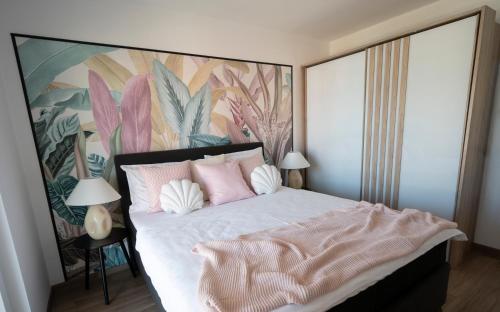 a bedroom with a large bed with pink pillows at Appartments Smrikve in Medulin
