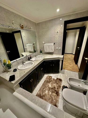 a bathroom with two sinks and a toilet and a mirror at Le Vélodrome au cœur de Casablanca in Casablanca