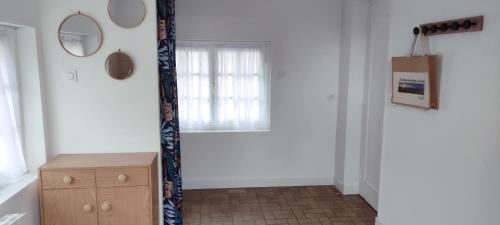 a room with a window and a wooden dresser at Maison individuelle plein pied in Bray-Dunes