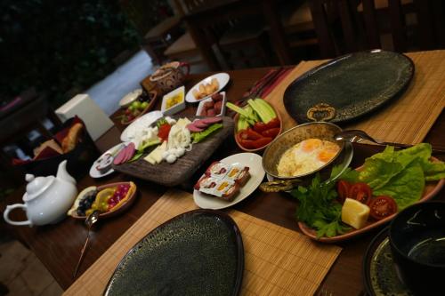 a wooden table with plates of food on it at OzenTurku Hotel in Pamukkale