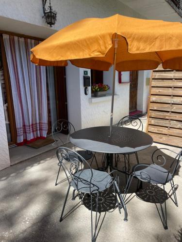 Chabottes的住宿－Pont de Frappe，庭院内桌椅和遮阳伞