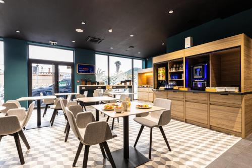 a dining room with tables and chairs in a restaurant at Holiday Inn Express Ajaccio by IHG in Ajaccio