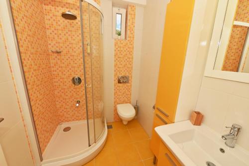 a bathroom with a shower and a toilet and a sink at Villa Velestovo in Ohrid