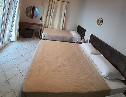 1 dormitorio con 2 camas y ventana en Aggeliki Apartments, en Nikiana