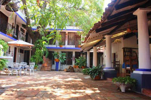 a courtyard of a house with tables and chairs at Hotel Misi&oacute;n y Spa in Acapulco