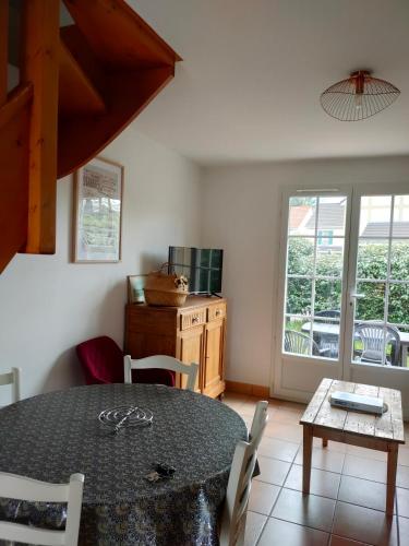 une salle à manger avec une table et des chaises et une cuisine dans l'établissement Entre terre et mer, à Camiers